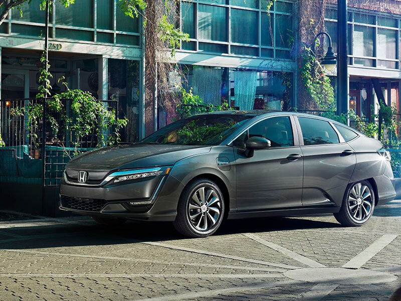 Honda Clarity A Silver Honda Clarity sedan parked on a street next to a building.